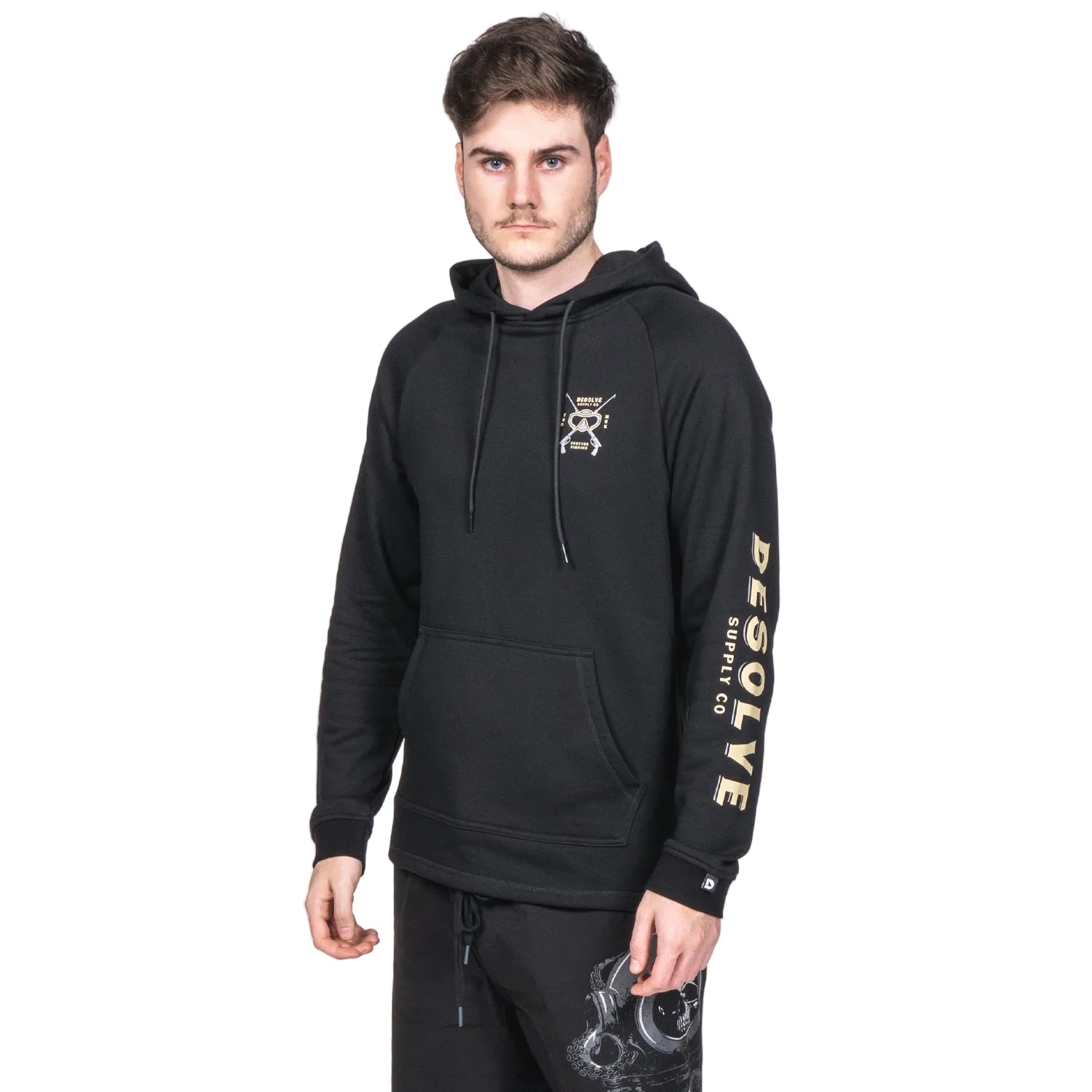 A male model wearing a black midweight hoodie with a graphic print on the front and the sleeve, standing against a white background.