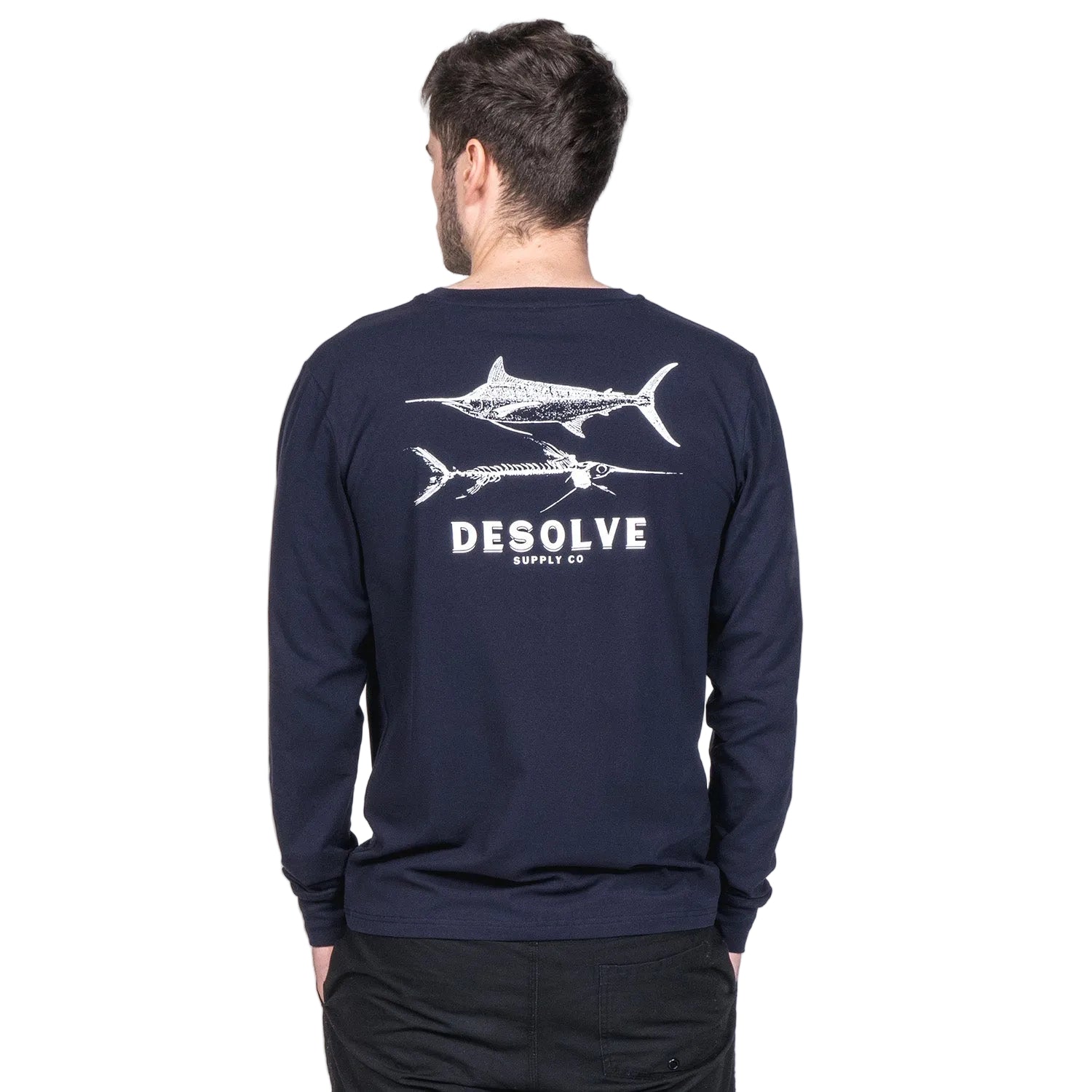 A person wearing a navy long-sleeve t-shirt with a graphic print of fish and the brand name 'DESOLE' on the back.
