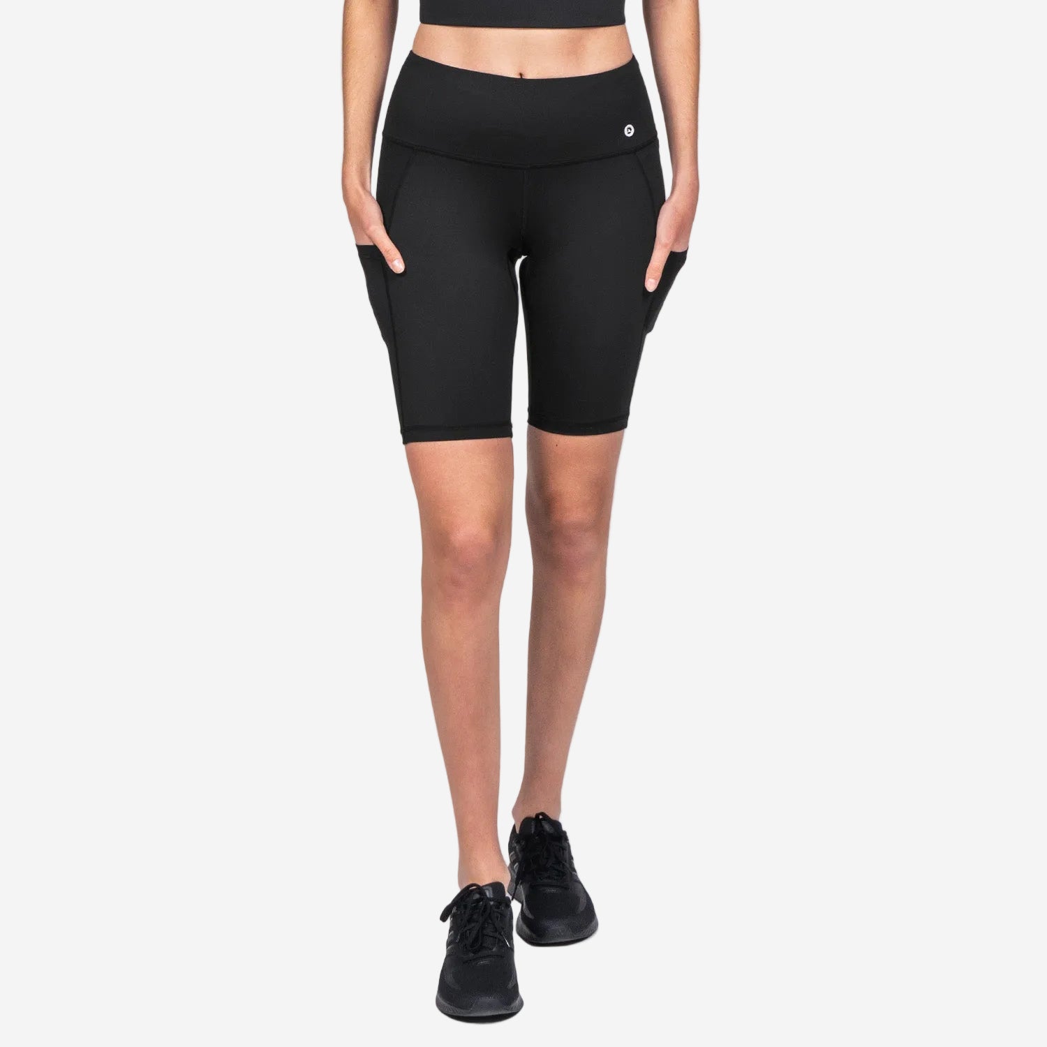 A pair of black above-knee-length biker shorts with a high waist, side pocket, and internal waist drawstring. The shorts are designed with flatlock seams and have UPF 30+ sun protection.