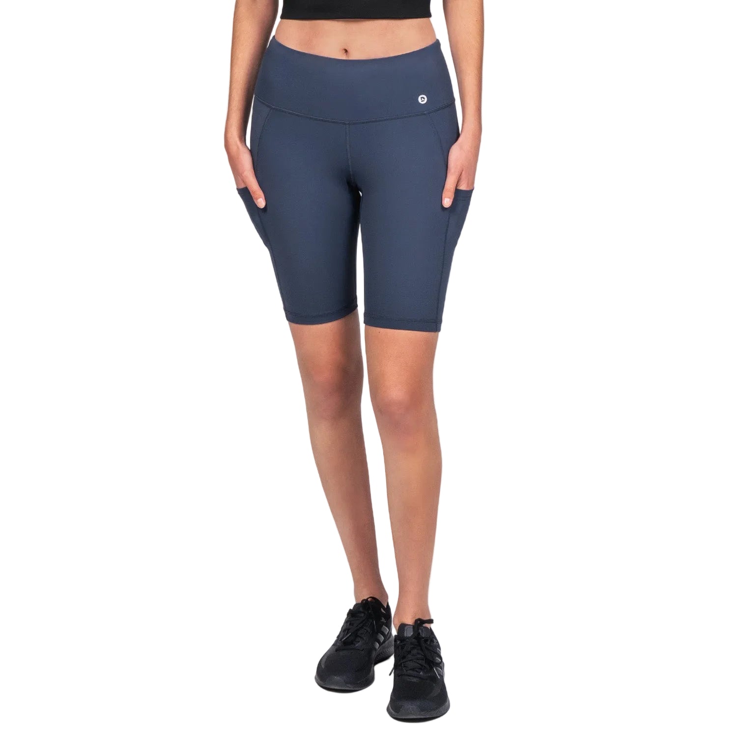 A pair of navy blue above knee-length biker shorts with a high waist, side pocket, and flatlock seams, modeled by a woman.