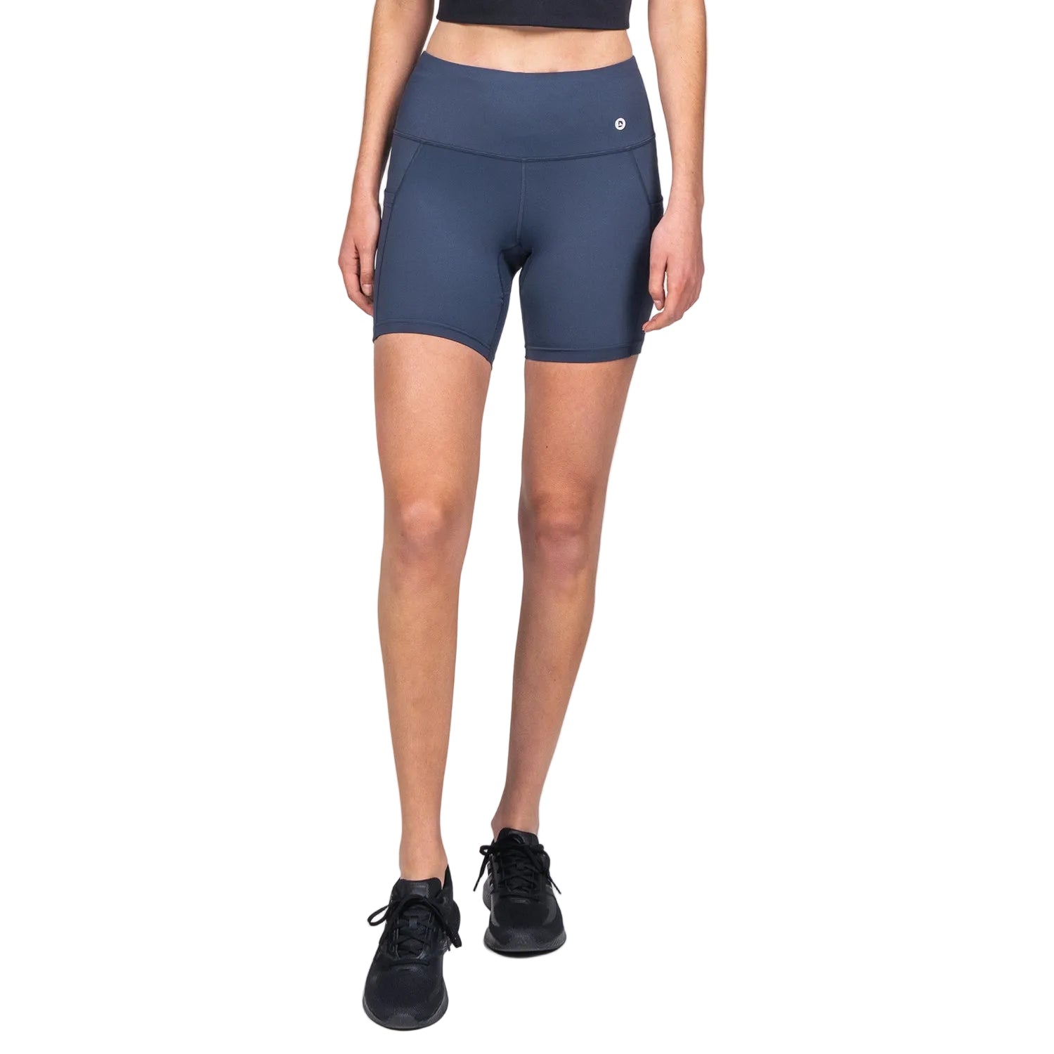 A pair of navy blue midi biker shorts with a high waist, side pocket, and internal drawstring. The shorts fall mid-thigh and have a screen-printed logo on the left leg.